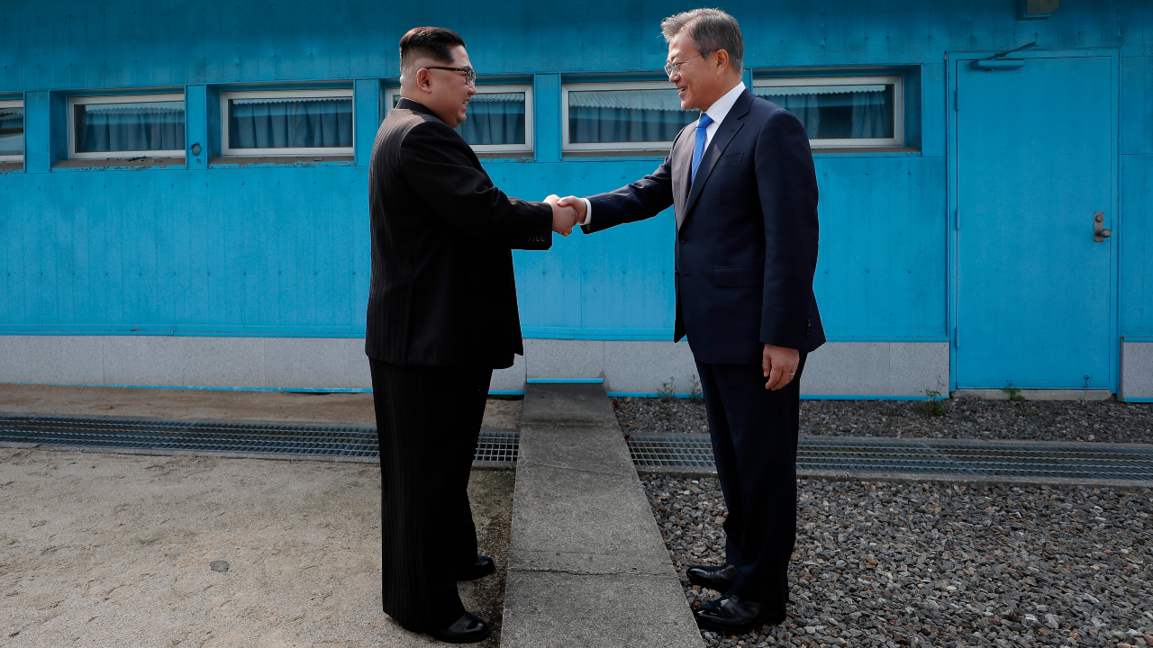 O l&iacute;der supremo da Coreia do Norte, Kim Jong-un, e o ex-presidente da Coreia do Sul, Moon Jae-in, apertando as m&atilde;os da regi&atilde;o fronteiri&ccedil;a de Panmunjom